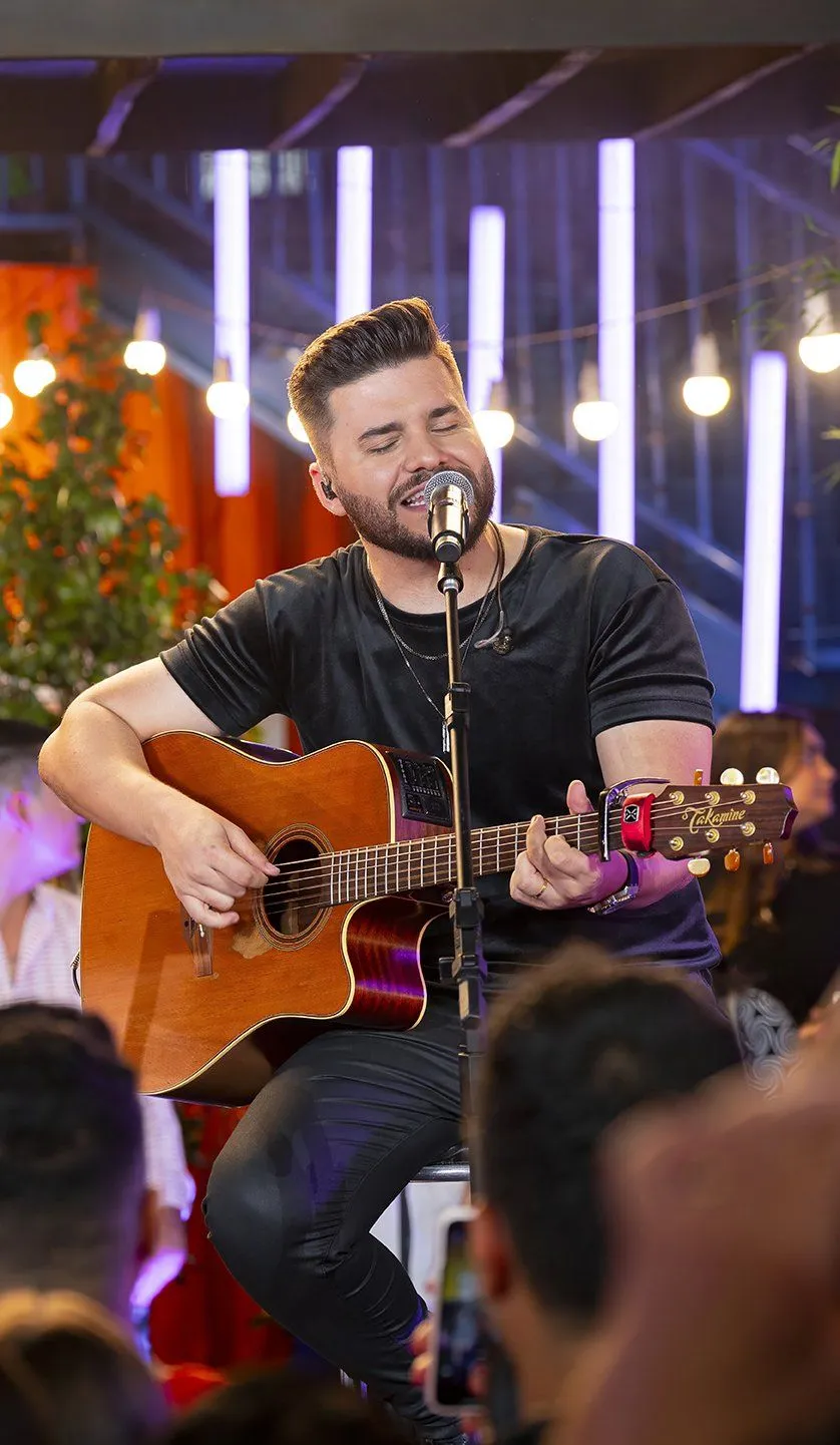 Mateus tocando violão no palco