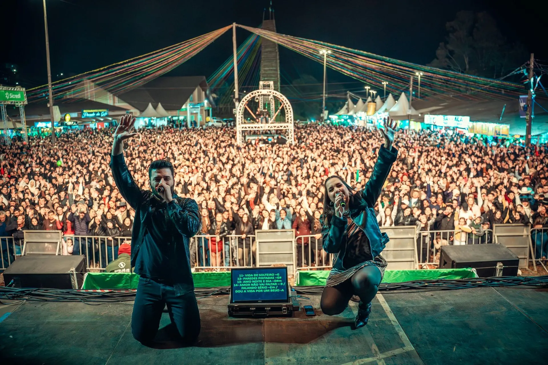 Mariana e Mateus no palco diante de uma multidão